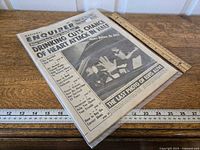 Full view of newspaper in sleeve with rulers for scale