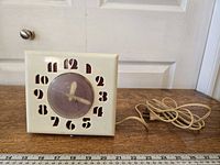 Front view of square cream Telechron electric clock with power cord visible