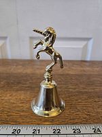 Front view of brass unicorn bell showing full figure and bell body