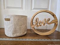 Wood sign and canvas bucket side by side with ruler for scale