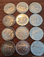 Top view of 12 Canadian silver quarters spread in grid showing reverse with cougar design and dates 1867-1967.