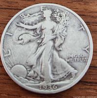 Obverse side of the 1936 American silver half dollar showing Lady Liberty walking with sun in background and date 1936.