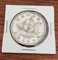 Photo of the reverse side of the 1949 Canadian silver dollar showing the Bluenose schooner, date, and inscriptions.
