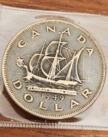 Photo of the full coin showing the Bluenose schooner with inscriptions 'CANADA DOLLAR' and the year '1949'.