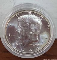 Obverse side showing John F. Kennedy profile, date 1964, and inscriptions.