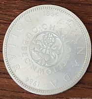 Reverse side of the 1964 Canadian silver dollar coin showing floral emblem and 'Canada Dollar' markings with year.