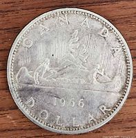 Reverse of the 1966 Canadian silver dollar showing the voyageur canoe scene with date and country inscriptions.
