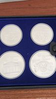 Four sterling silver coins housed in blue presentation case