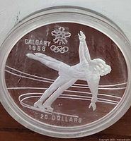 Obverse side of 1988 Calgary Winter Games $20 silver coin showing speed skater and Olympic logo.