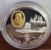 Front side of the coin showing Curtiss HS-2L seaplane, water reflection, trees, and gold-covered oval portrait cameo.