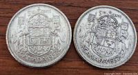 Both 1957 Canadian silver half dollar coins visible on wooden surface