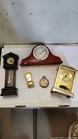 Group of five timepieces on table