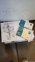 Overview of wiring diagram sheet with blue and green manuals stacked