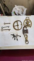 Group shot showing all keys, belt buckle, horse brass, padlock, swivel hook