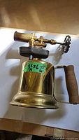 Side view of brass blowtorch showing body, burner and control wheel