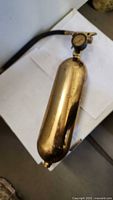 Full view of brass fire extinguisher showing cylinder and hose