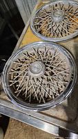Two matching wire spoke hubcaps placed side by side