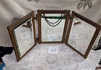 Front view of three hinged beveled mirrors with chain