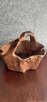 front view of carved burl wood basket showing handle and live-edge rim