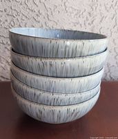 Stack of five Denby Halo Speckle bowls showing exterior glaze
