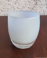 Front view of white Glassybaby votive showing clear base and opaque body