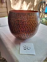 Exterior of hammered copper planter showing shape and texture