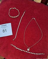 All four jewellery pieces laid out on red fabric