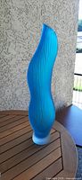 Front view of tall blue ribbed sommerso vase on table