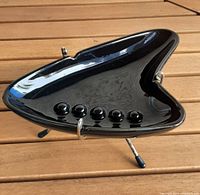 Top angle view of black boomerang ashtray on metal stand