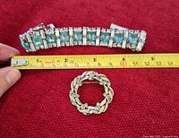 Bracelet and brooch with tape measure indicating sizes