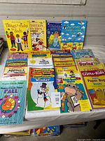 Overall view of 30 assorted children’s activity and classroom resource books spread on table