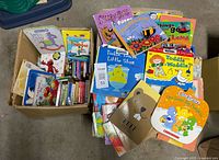 Two boxes filled with assorted colorful children’s board and picture books, showing variety and quantity