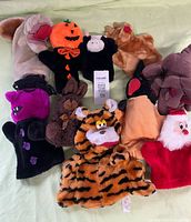 Group shot of all ten plush hand puppets arranged on surface