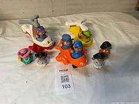 Overall shot showing two helicopters, airplane, and eight figures