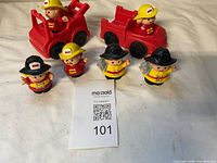 Overall shot of both red fire vehicles and five firefighter figures