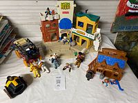 Overview of entire lot showing playset buildings, stagecoach, cannon, wagon and figures