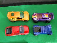 Top view of all four cars: yellow Nissan 300ZX, purple Quick Sander, red Chevy Silverado, blue RV770