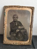 Front view showing photo of elderly man and ornate brass frame