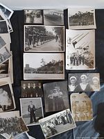 Overview of assorted naval photographs laid out on dark surface