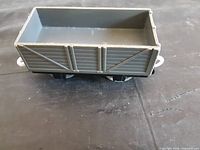 Overall view of grey open-top wagon, black chassis, white coupler