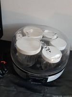Top view of yogurt maker showing five small jars under clear lid