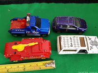 All four cars laid out beside tape for scale