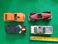 Top view of all four die-cast cars with ruler for scale