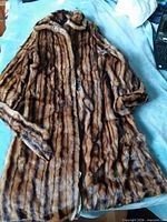 Front view of brown striped fur coat shell laid flat