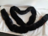 Entire length of fur scarf coiled on surface