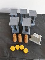 Five grey KidKraft pillars, three brown wedges, four yellow caps, one grey connector