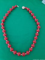 Full view of red bead necklace laid flat