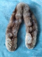 Full view of brown fur scarf on blue surface