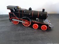Left side view of black and red locomotive toy