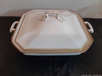 Top view of lidded serving dish showing lid shape, finial and gold trim